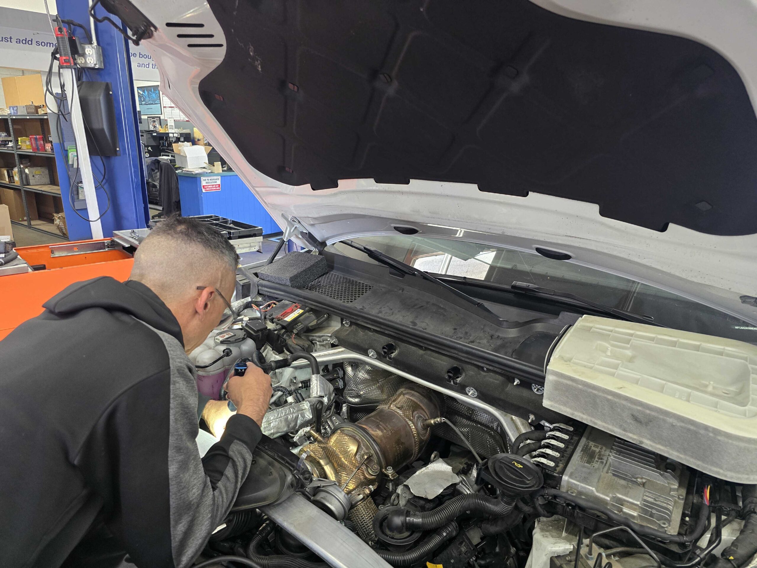 ASE-certified technician performing a fluid flush at Euro Car Clinic in Signal Hill, CA